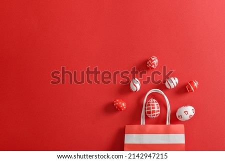 Paper eco-bag with painted Easter eggs on a red background. Banner for a happy Easter holiday. Space for copying. Flat position, top view.