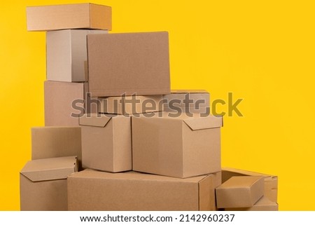 Boxes of various sizes. Several boxes are in pile. Cardboard boxes on yellow background. Concept of parcels ready to be sent. Metaphor cardboard with goods from online store. Courier shipments Royalty-Free Stock Photo #2142960237