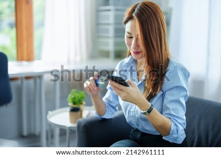 Online Shopping and Internet Payments, Portrait of Asian woman are using their credit cards and to smart mobile phones shop online or conduct errands in the digital world.
