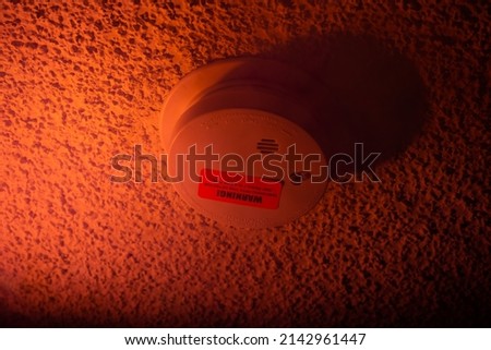 Fire alarm button in the house. Isolated on an orange background. Fire safety, danger warning, evacuation. There are no people in the photo. There is free space to insert.