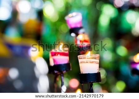 The candle is lit in a glass with a blurred background. Noisy in the picture