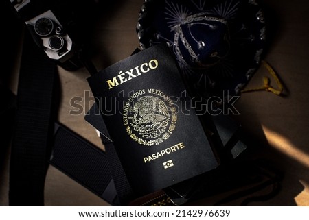 high angle,new biometrical passport with electronic icon and some icons of Mexican culture and camera . Translation on cover text  "Mexico-United States of Mexico- passport".