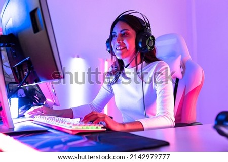 young  playing game online at home. Gamer  controlling joystick for video game. Teenage girls leisure game in neon light room at home.