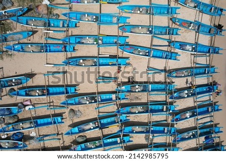 aerial photography of white sandy tropical beach with blue fishing boats lined up neatly on the shore. clear watery beach, green tosca. Pantai Ngrenehan in Yogyakarta Indonesia. kapal nelayan.