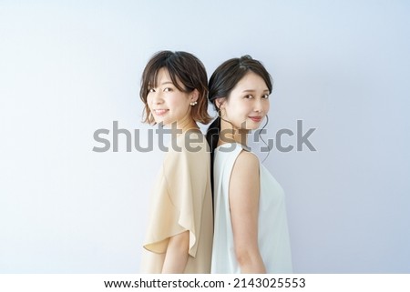 Two young women lined up with a smile