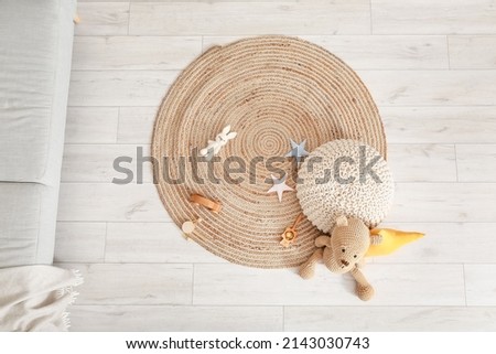 Wicker carpet with pouf and toys in children's room Royalty-Free Stock Photo #2143030743