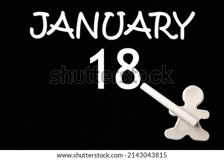 18th day of January. A small white plasticine man writing the date 18 January on a black board. Business concept. Education concept. Winter month, day of the year concept.