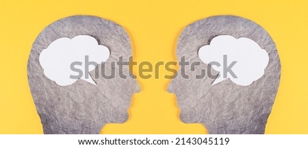 Silhouette of two faces, speech bubble in white color, copy space for text, communication, having an opinion and discussion, free speech, people talking, yellow background Royalty-Free Stock Photo #2143045119