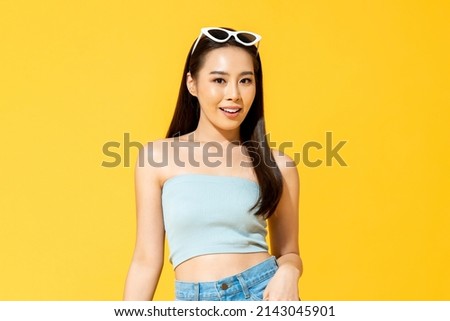 Waist up summer portrait of Asian woman in studio isolated yellow color background