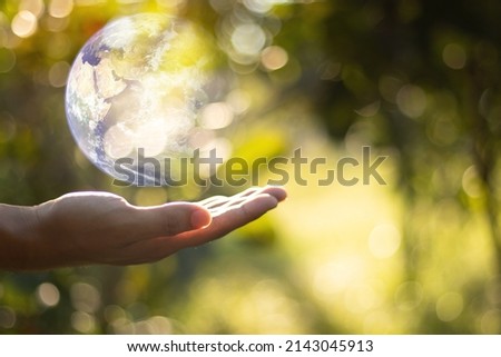 Together we can save the world and offer the better world for our children and Earth day concept, Butterfly and love heart shaped earth on hands, Elements of this image furnished by NASA Royalty-Free Stock Photo #2143045913