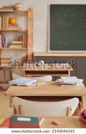 Vertical background image of wooden school desks in row facing blackboard in empty classroom Royalty-Free Stock Photo #2143046561