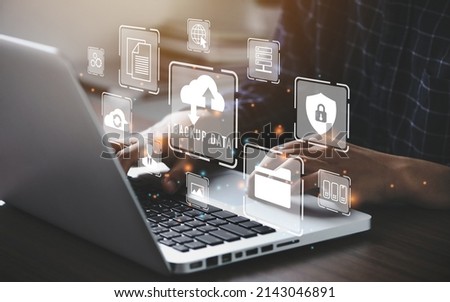 Businessman using a computer to backup storage data Internet technology concept for backup online documentation database and digital file storage system or software,file access, doc sharing. Royalty-Free Stock Photo #2143046891