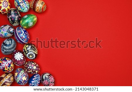 Red Easter card. Beautiful Easter multi-colored eggs on a red background, space for text.