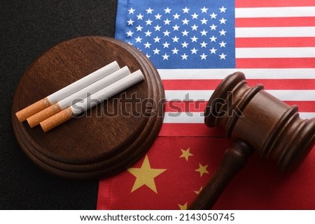 Cigarettes and Judge gavel on background of flag USA and China. Transportation of illegal tobacco goods. Smuggling