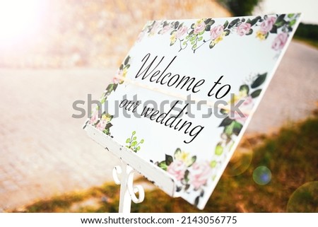 Wedding concept photo. Welcome to our wedding message on a floral board at the entrance of the event ceremony venue.