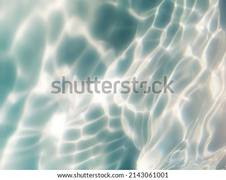 Blur​ abstract​ of​ surface​ blue​ water. Abstract​ of​ surface​ blue​ water​ reflected​ with​ sunlight​ for​ background.Top​ view​ of blue​ water.​ Water​ splashed​ use​ for​ graphic​ design.