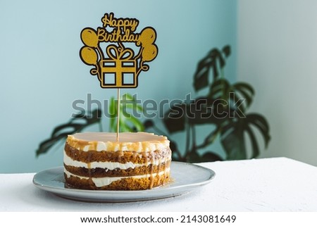 Cake with Birthday topper. Copy space. Blurred background.