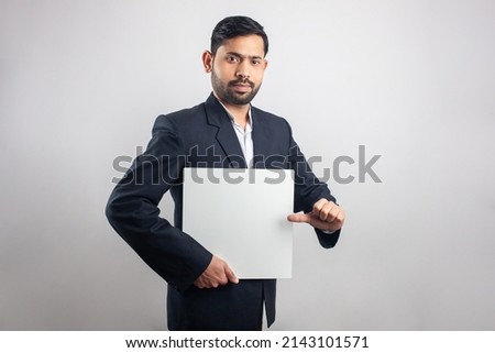 business man pointing thumb towards empty white board in white background