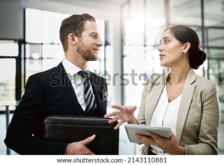 His constructive criticism is always helpful. Cropped shot of two businesspeople looking at a tablet in the office. Royalty-Free Stock Photo #2143110881