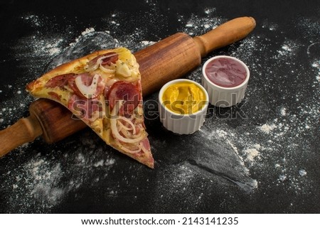 Pepperoni pizza slice on roll
with black background.
