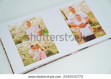 on white background open a photobook from a family photo shoot in the spring garden. Tradition print photo album and review and remember moments of life. services of photographer and designer.