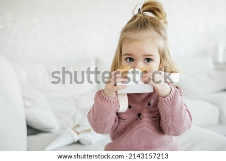 Small adorable girl holding wooden toy photo camera and take picture. Talented children