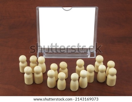 Advertising stand with copy space for text and wooden people figures on table. 