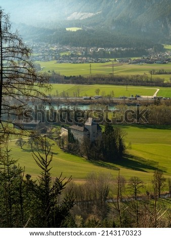 Light value Castle, medieval castle in the Inn Valley near Munster. wonderful spring-like view from the mountain, with snowy mountains in the background and green meadows and forests.  Royalty-Free Stock Photo #2143170323