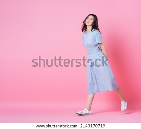 Full length image of young Asian woman wearing blue dress on pink background Royalty-Free Stock Photo #2143170719
