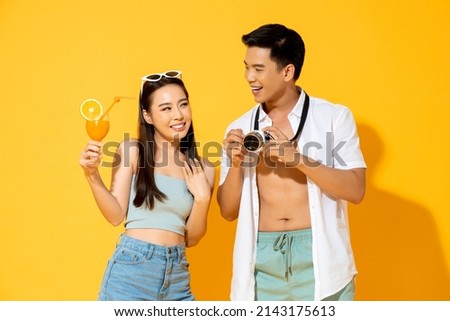 Summer portrait of happy young Asian couple in studio isolated yellow color background