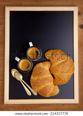 two hot croissant & two cup of fresh coffee espresso on slate chalkboard on wood background 