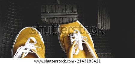 Shoes under brakes of the car will cause danger and accidents to the driver. Royalty-Free Stock Photo #2143183421