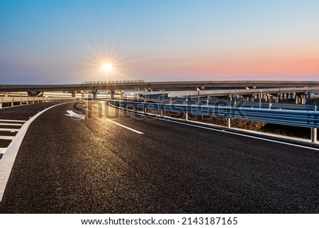 Empty asphalt highway and street lights with beautiful sky at sunset Royalty-Free Stock Photo #2143187165