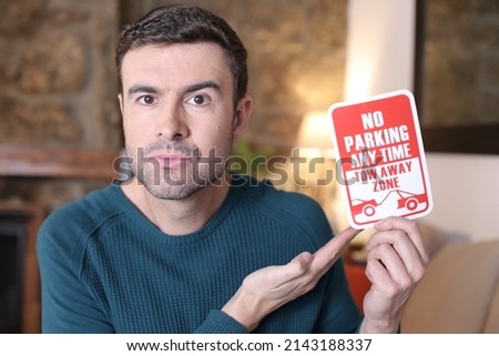 Man holding no parking sign
