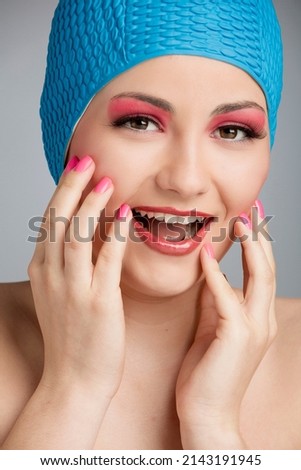 Funny portrait of a beautiful woman wearing a swim cap