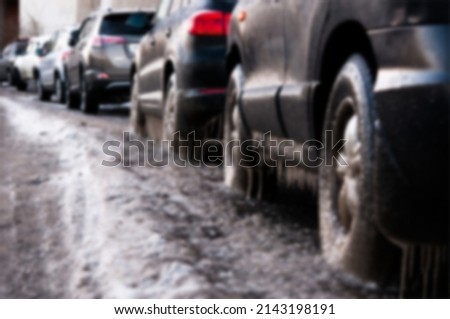 Car wheels and frozen water in winter in blurry view