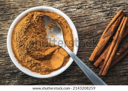 Dry cinnamon sticks and cinnamon powder on a wooden table. Top view. Cinnamon spice.