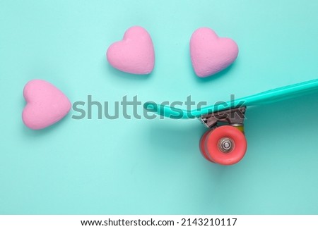 Skateboard with hearts on blue background. Love concept. Top view. Flat lay