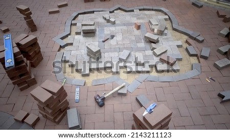 Brick hardscaping project showing two tone design with gardens around. Royalty-Free Stock Photo #2143211123