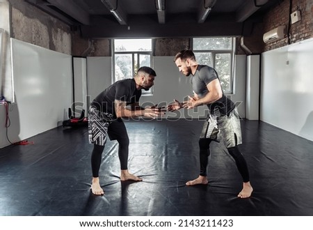 Sparring training of two athletic mma fighters in the gym. Martial arts, Wrestling