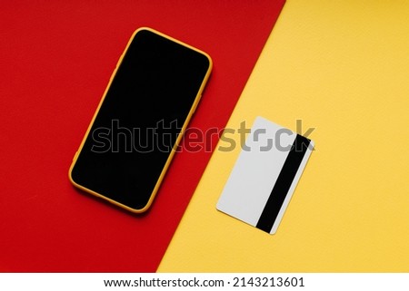 Smartphone with credit card on colorful background. Business concept or online shopping.