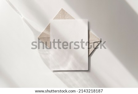 Mockup blank greeting card. Composition with shadows from a glass goblet on white background.  Royalty-Free Stock Photo #2143218187