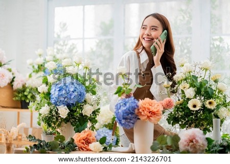 taking order florist working from home,young asian florist making list from client order to arrange flower bouqet vase delivery, Flower design store. happiness smiling young lady making flower vase  Royalty-Free Stock Photo #2143226701
