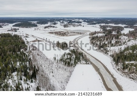 Winter landscape over the forest and the river. Drone photo. Finland, Scandinavia.Cloudy day