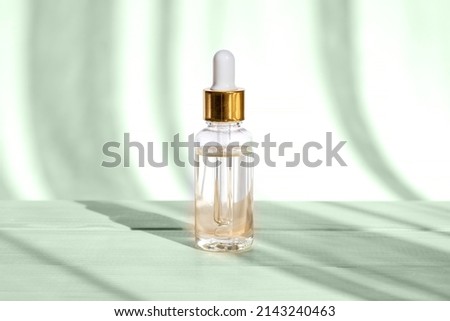 Natural oil cosmetics. Dropper glass Bottle Mock-Up. Oily cosmetic pipette. Face and body treatment. Spa concept. Mineral organic liquid. Front view. Beauty products. Blank packaging on wooden table.