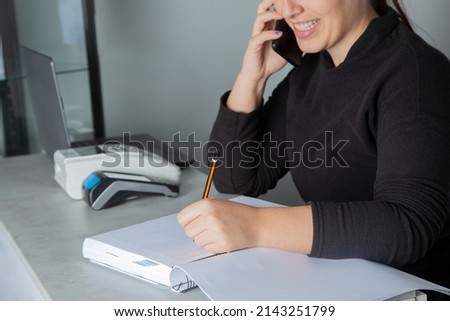 Smiling woman writing an appointment in her notebook