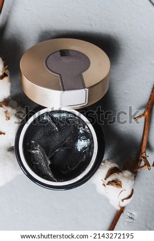 black body scrub in a black jar with decor