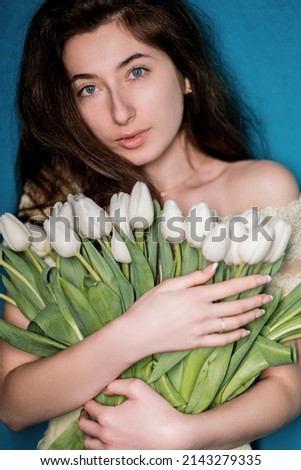 charming ukrainian woman with blue eyes holding beautiful tulip flowers