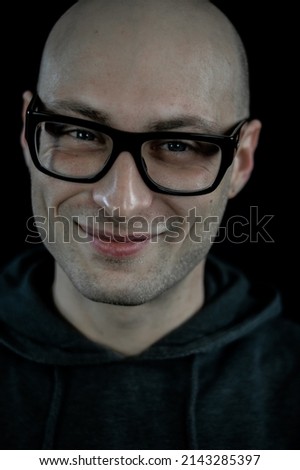 Portrait of a bald young man with eyeglasses smiling