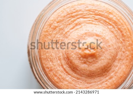 Pollack fish caviar, in a white creamy sauce, in an open glass jar. Macro. White background. View from above. Close-up
